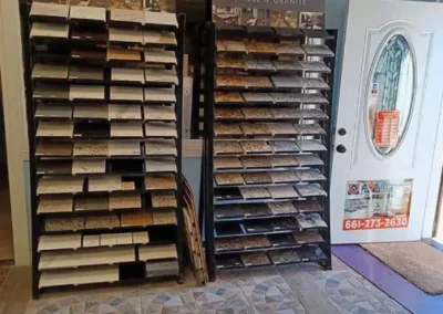 A showroom with racks of marble and granite samples beside an open door